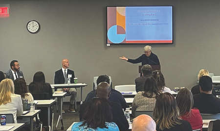 Illinois Supreme Court Chief Justice Theis gives closing remarks at the learning event and thanks Superintendent Mike Davis (seated immediately to her right) for leading a discussion on the lived experiences of detained youth. 