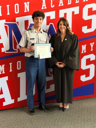Santiago Garcia (Junior, 2nd Place) left, with Judge Kimberly DiGiovanni, and Kane County Bar Foundation President Katie Doyen (not pictured) at Marmion Academy — Santiago receives his $250 check, Law Day swag bag, and certificate. Photo provided by Katie