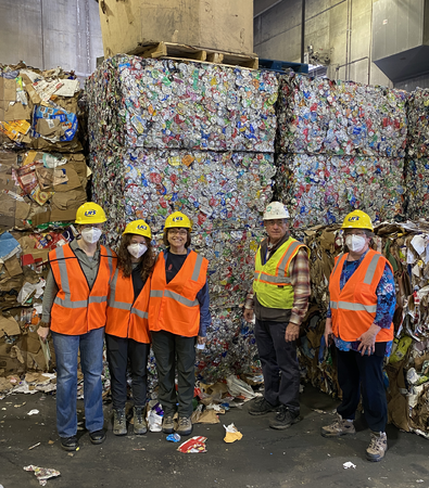 The Kane County tour group poses in front of several tons of baled aluminum.