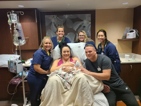 Parents Rachael Dewitt and Tomas Kuras pose for a picture with their newborn, Lukas, and delivery staff at Rush Copley Medical Center.png