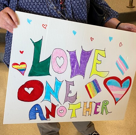 Resident at County Board meeting June 27, 2023 holds sign in support of Pride Proclamation