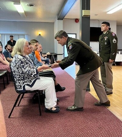 Picture of Anna Green Showerman accepting the Purple Heart Medal on behalf of her late father World War II U.S. Army Staff Sergeant John W. Green.