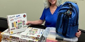 Kane County Regional Superintendent Patricia Dal Santo shows some of the new school supplies that ROE has to help Kane County students have a successful school experience.  Photo credit:  Kane County ROE 