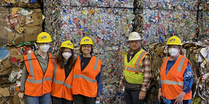 The Kane County tour group poses in front of several tons of baled aluminum.