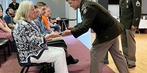 Picture of Anna Green Showerman accepting the Purple Heart Medal on behalf of her late father World War II U.S. Army Staff Sergeant John W. Green.